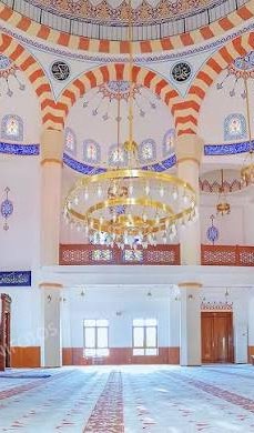 Mosque interior with chandelier and mihrab